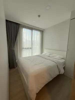 a white bedroom with a large bed and a window at Sky Park Family Comfort in Laguna Phuket