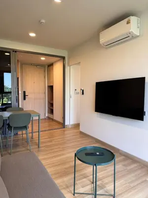 a living room with a flat screen tv on a wall at SkyPark Laguna, 1 Bedroom Apartment in Phuket