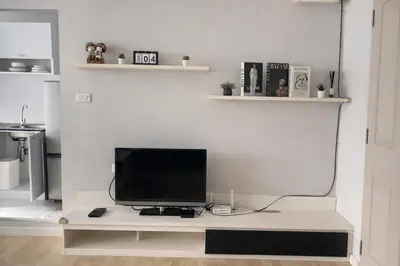 a television sitting on a desk in a living room at studio room dami in Kathu