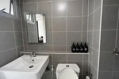 a bathroom with a sink and a toilet and a mirror at studio room dami in Kathu