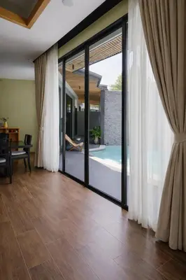 an open living room with sliding glass doors at Private Pool Villa Baan Bua in Phuket Town