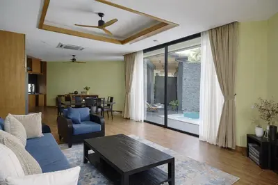 a living room with a couch and a table at Private Pool Villa Baan Bua in Phuket Town