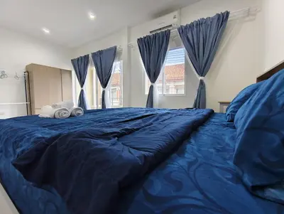 a large blue bed in a bedroom with blue curtains at The Blue Oasis Cozy Phuket Getaway in Ban Ket Ho