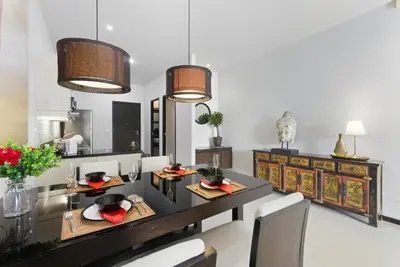 a dining room with a table and chairs and lights at Onyx Villa by Beringela in Rawai Beach