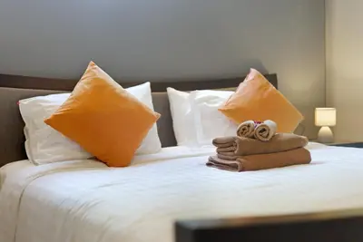 a bed with pillows and towels on it at Onyx Villa by Beringela in Rawai Beach