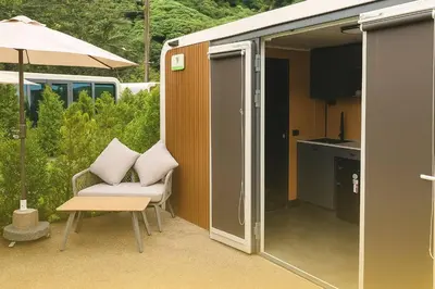 a small house with a chair and an umbrella at Apple House seaside home and pool in Ban Lum Fuang