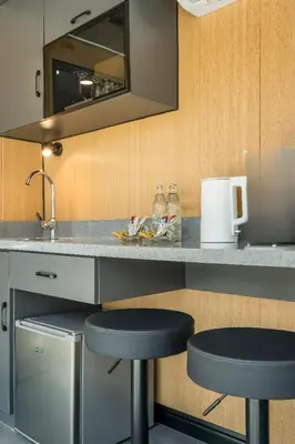 a kitchen with two bar stools at a counter at Apple House Phuket a cozy home terrace &pool&beach in Ban Lum Fuang