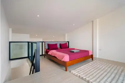 a bedroom with a bed with pink sheets and pink pillows at Patong Boutique in Patong Beach