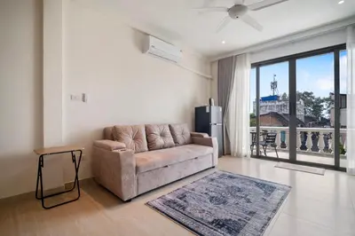 a living room with a couch and a large window at Patong Boutique in Patong Beach