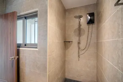 a bathroom with a shower with a glass door at Patong Boutique in Patong Beach