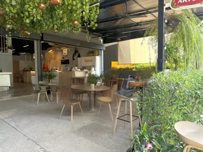 a restaurant with tables and chairs and plants at Apple House Rental in Bangtao, pool and breakfast in Ban Lum Fuang