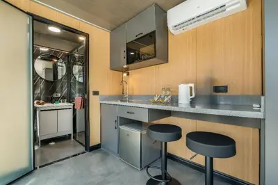 a small kitchen with two stools and a counter at Apple House Rental in Bangtao, pool and breakfast in Ban Lum Fuang