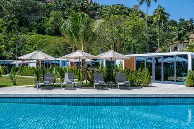 a pool at a resort with chairs and umbrellas at Apple House Comfort coziness beach pool, breakfast in Ban Lum Fuang