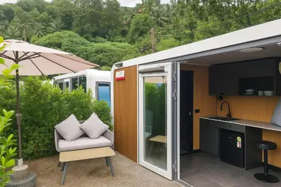 a small house with a chair and an umbrella at Apple House Phuket Near Beach with Pool & Terrace in Ban Lum Fuang