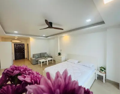a bedroom with a white bed and purple flowers at Lahan 4 in Patong Beach