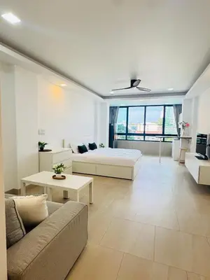 a white living room with a bed and a couch at Lahan 4 in Patong Beach