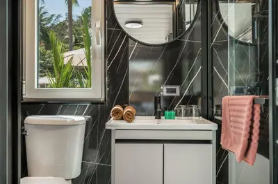a bathroom with a toilet and a sink and a mirror at Apple House Beach Access, Pool & Breakfast in Ban Lum Fuang