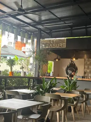 a restaurant with tables and chairs and a sign at Apple House Bangtao with Pool & Terrace, beach in Ban Lum Fuang