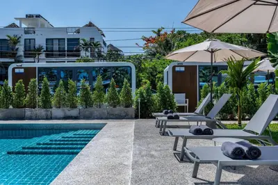 a pool with lounge chairs and an umbrella at Apple House Stylish Seaside Retreat with Breakfast in Ban Lum Fuang