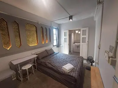 a bedroom with a bed and a desk in it at Fan Room Near Bangkok hospital Across Night market in Ban Ket Ho
