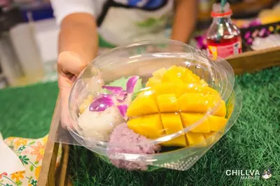 a person holding a plastic bowl of food with fruit at Fan Room Near Bangkok hospital Across Night market in Ban Ket Ho