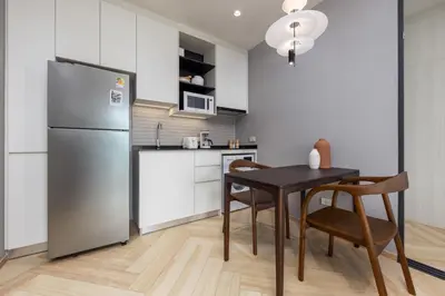 a kitchen with a black table and a refrigerator at Evora 1BR Suite — The Title Legendary BangTao in Bang Tao Beach