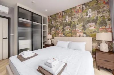 a bedroom with a large white bed with towels on it at Evora 1BR Suite — The Title Legendary BangTao in Bang Tao Beach