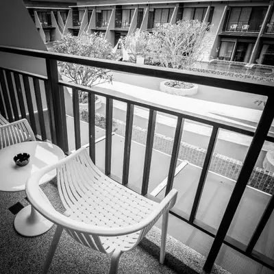 a balcony with a white chair and a table at The Phu Beach Hotel - SHA Plus in Ao Nang Beach
