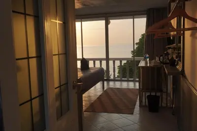 an open door to a balcony with a view of the ocean at Residy Hideaway in Patong Beach