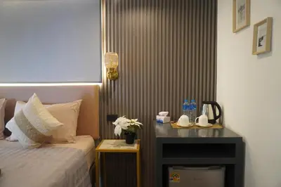 a hotel room with a bed and a table with flowers at Residy Hideaway in Patong Beach