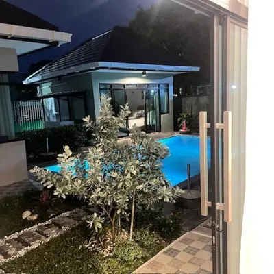 a house with a swimming pool at night at Stingless Villa in Ban Ket Ho