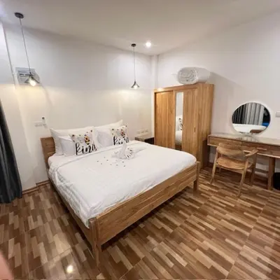 a bedroom with a large bed and a desk at Stingless Villa in Ban Ket Ho