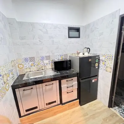 a small kitchen with a sink and a refrigerator at Stingless Villa in Ban Ket Ho