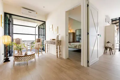 a living room with a table and a bedroom at Sarah Place Private Tropical Villa in Ban Pak Lak