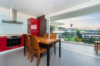 a kitchen with a wooden table and chairs and a large window at Convenient apartment at Karon Butterfly by Lofty in Karon Beach