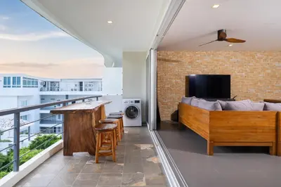 a living room with a couch and a television on a balcony at Convenient apartment at Karon Butterfly by Lofty in Karon Beach