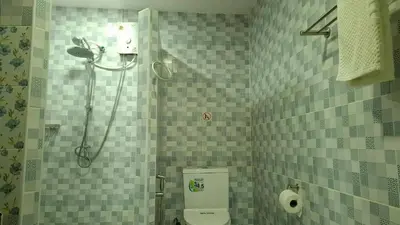 a bathroom with a toilet and a shower in it at Gentle Guesthouse in Patong Beach