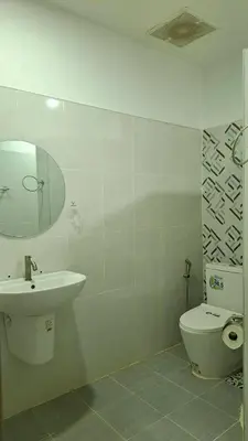 a white bathroom with a sink and a toilet at Gentle Guesthouse in Patong Beach