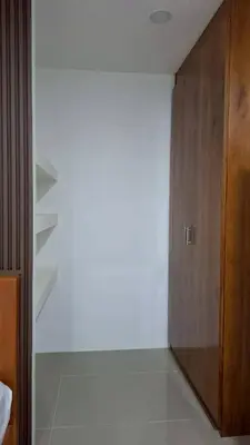a room with a white wall and a wooden door at Gentle Guesthouse in Patong Beach