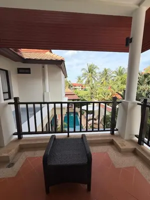a balcony with a chair and a view of the ocean at Tropical Thai style 4 bedroom pool villa in Laguna Phuket