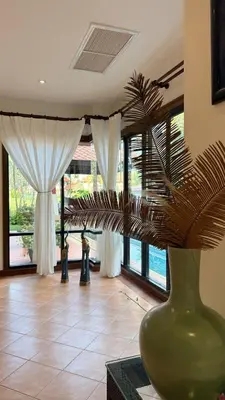 a green vase with a plant in a room with windows at Tropical Thai style 4 bedroom pool villa in Laguna Phuket