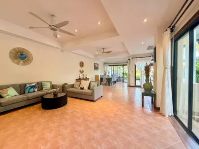 a living room with couches and a ceiling fan at Tropical Thai style 4 bedroom pool villa in Laguna Phuket