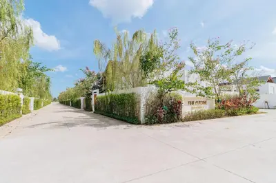 a road with a fence and trees on the side at V277 Famous Ozone Resort Calm Area Near Beach in Thalang
