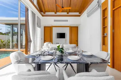 a dining room with a table and chairs at V277 Famous Ozone Resort Calm Area Near Beach in Thalang