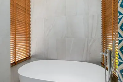 a white bath tub in a bathroom with windows at V277 Famous Ozone Resort Calm Area Near Beach in Thalang