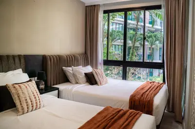 two beds in a hotel room with a window at Cozy 1 Bdr Royal Lee Nayang beach in Ban Bo Han