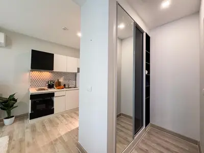 a kitchen with white walls and a sliding glass door at Cozy 1 Bdr Royal Lee Nayang beach in Ban Bo Han
