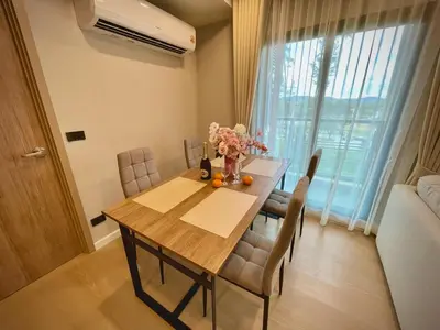 a dining room table with a vase of flowers on it at Family Space Condo 2 Bdr BangTao in Ban Thalat Choeng Thale