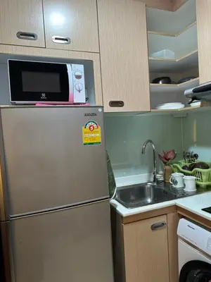 a small kitchen with a refrigerator and a sink at Cozy Condo with full kitchen Patong in Patong Beach