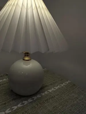 a white vase sitting on a table with a lamp at Cozy Condo with full kitchen Patong in Patong Beach